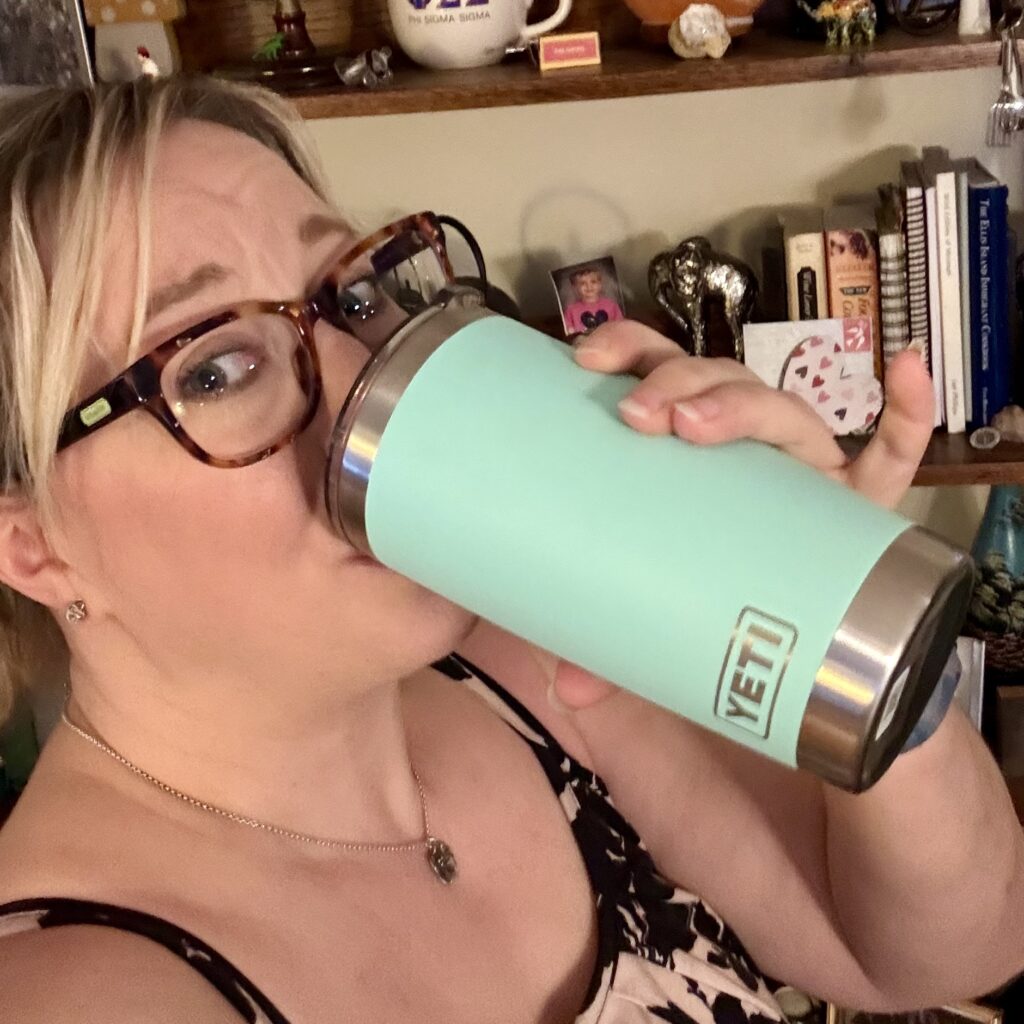 Ginny drinking out of her mint green Yeti travel mug.