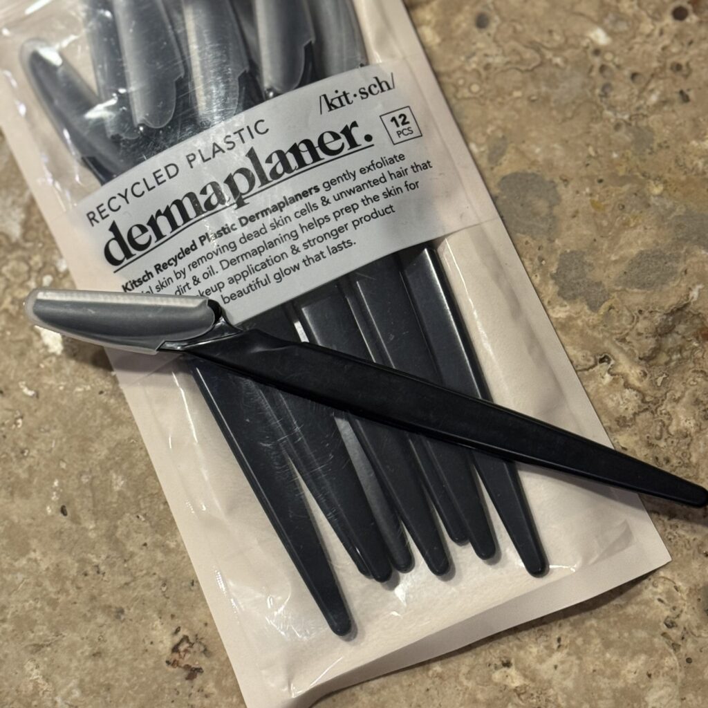 Kitsch dermaplaner for using under Ginny's chin to remove fine hairs for a smooth travel-ready finish.