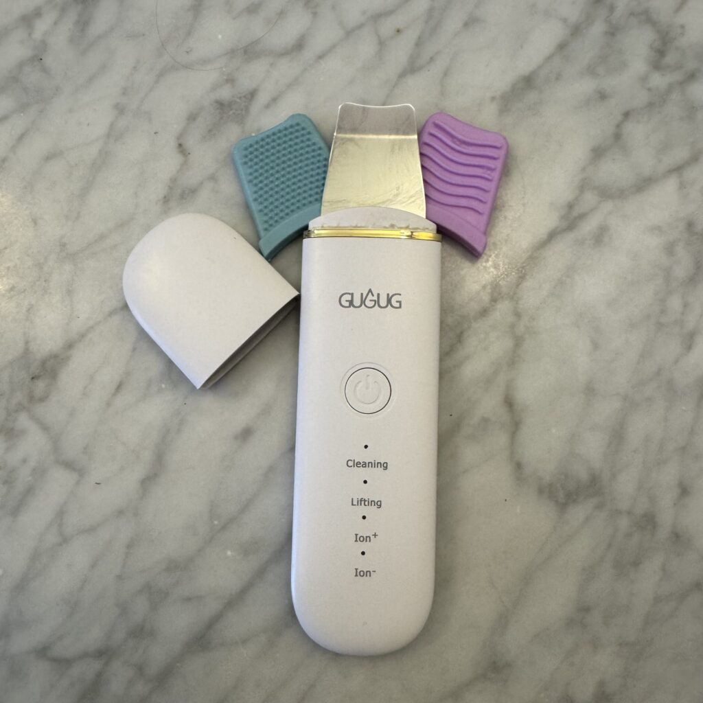 GUGUG skin scrubber face spatula and pore cleaner — lightweight ultrasonic facial cleansing tool with silicone covers, ideal for travel skincare.