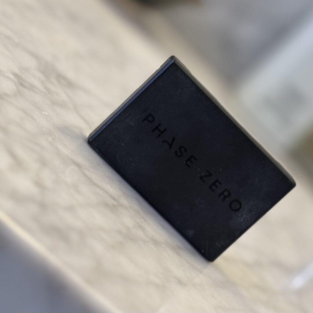 The tiny Phase Zero blush sits on a grey marble countertop.
