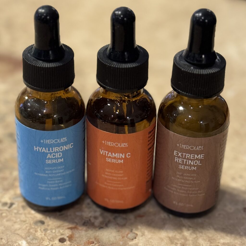 Close-up photo of +1herolabs travel serum set featuring retinol, vitamin C, and hyaluronic acid bottles, compact skincare for travel.