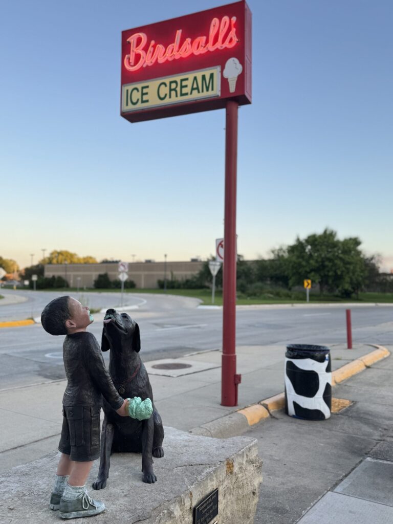 Birdsall’s Ice Cream neon sign with the boy-and-dog statue out front in Mason City, Iowa.