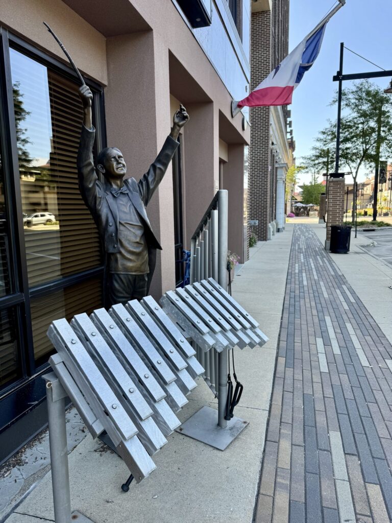 Sidewalk conductor statue with outdoor xylophone installation, downtown Mason City.