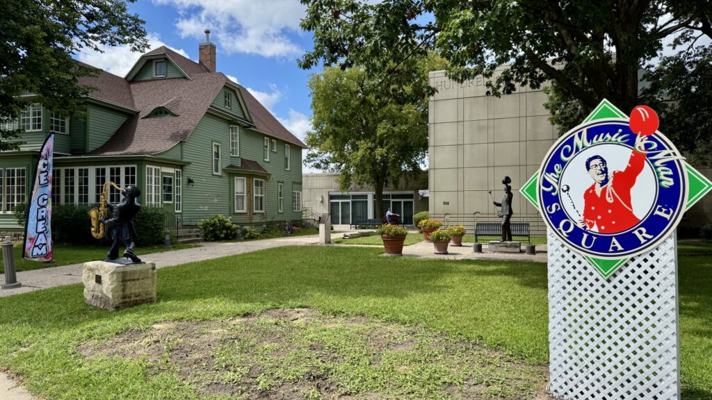 Music Man Square sign with Meredith Willson Boyhood Home and plaza statues in Mason City, Iowa.