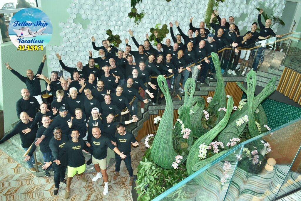 Group photo of sober travelers on a Fellow-Ship Vacations Alaska trip, all smiling and cheering.