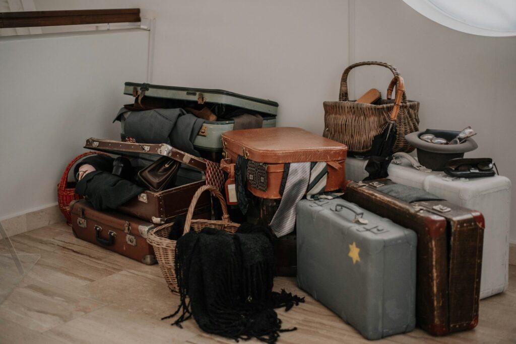 Stack of vintage suitcases and travel bags piled in a corner — the chaotic side of preparing for a long trip.