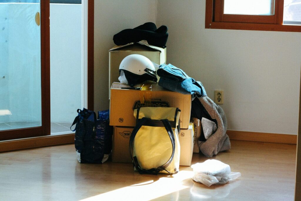 Messy pile of bags, clothes, and boxes in sunlight — the chaotic side of travel packing before the adventure begins.