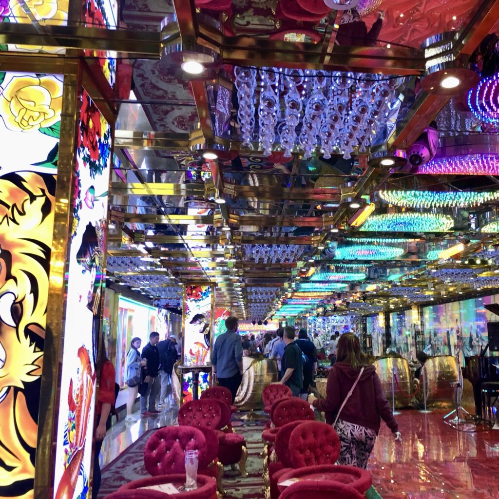A brightly lit, colorful, chaotic interior of the Robot Restaurant in Tokyo, Japan.