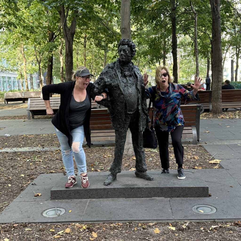 Ginny and her Aunt pose all silly style with a statue in a park in Montreal.