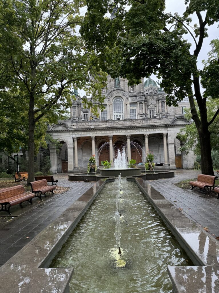 A long pool with fountains in front of a colonial style building in Montreal.