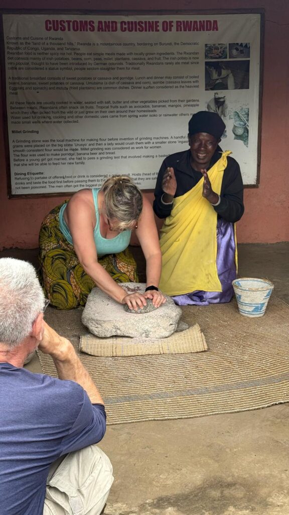 Ginny learns how to grind grain the traditional way in a cultural village in Rwanda.
