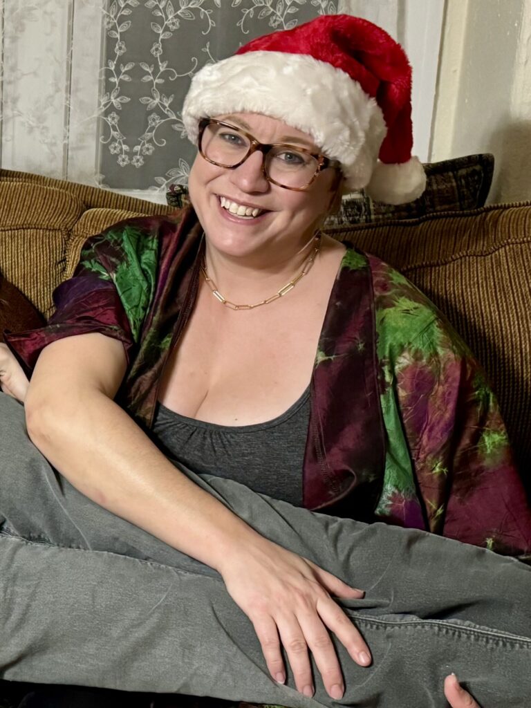 Ginny smiling in a Santa hat, a nephew lying across her lap.