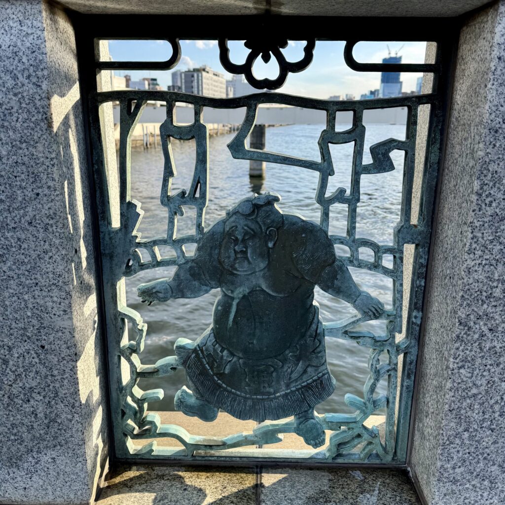 Ironwork image of a sumo wrestler in a cutout of a bridge in Tokyo - which we never would have seen if we hadn't been on a wander.